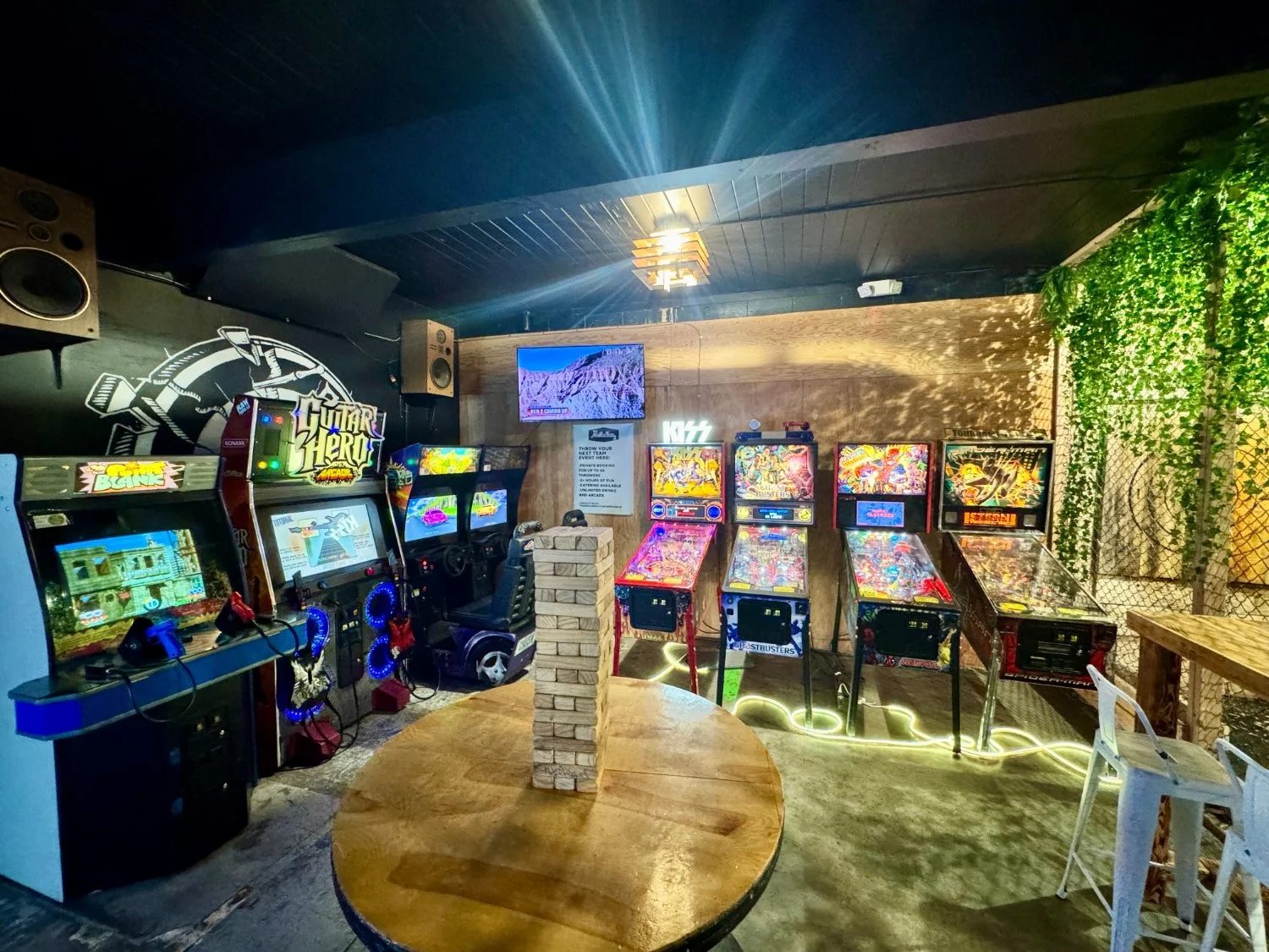 Arcade and pinball area with a large screen